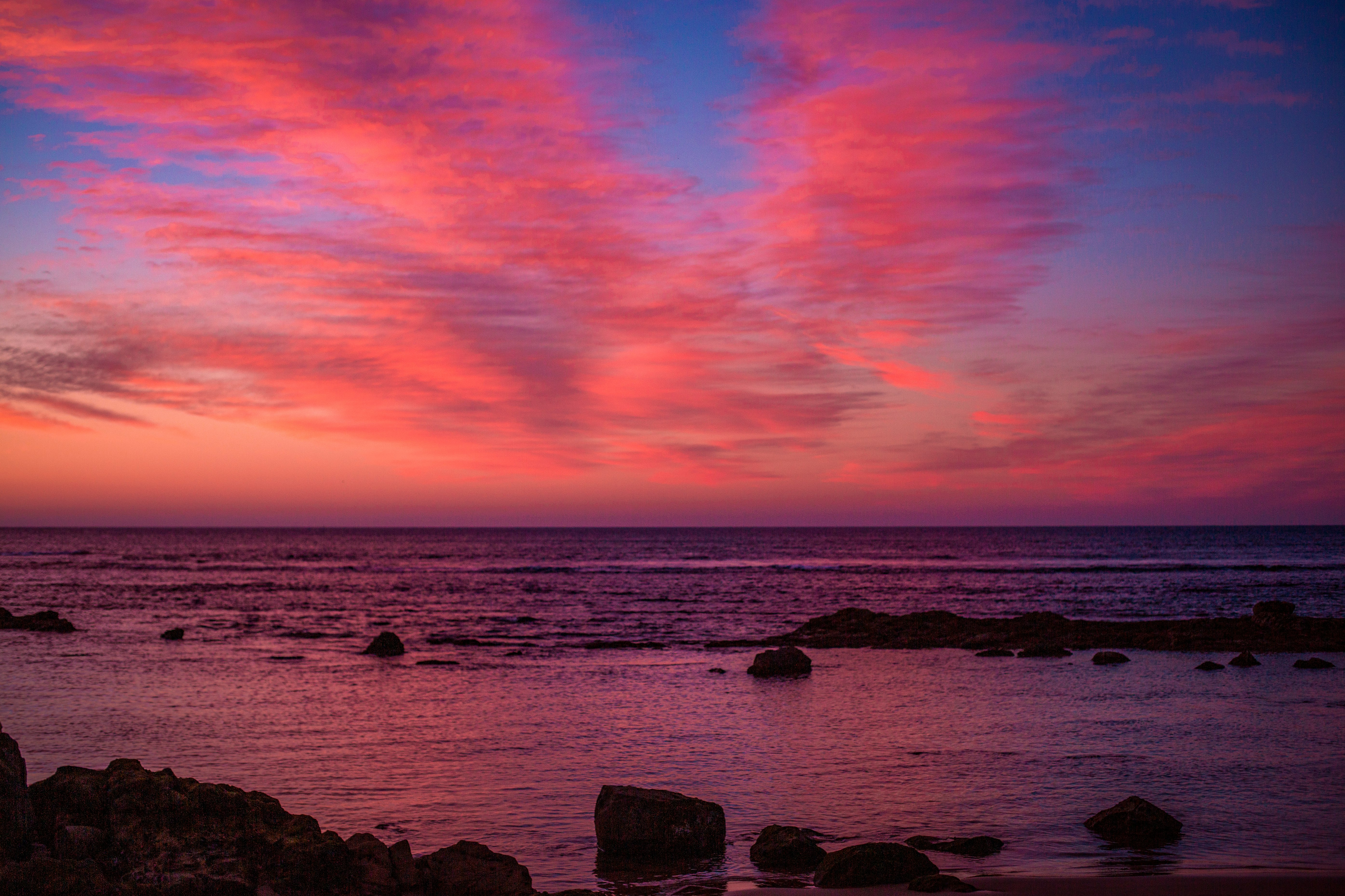 rocks on sea during sunset